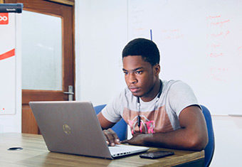 Man writing an entry level cover letter on his laptop